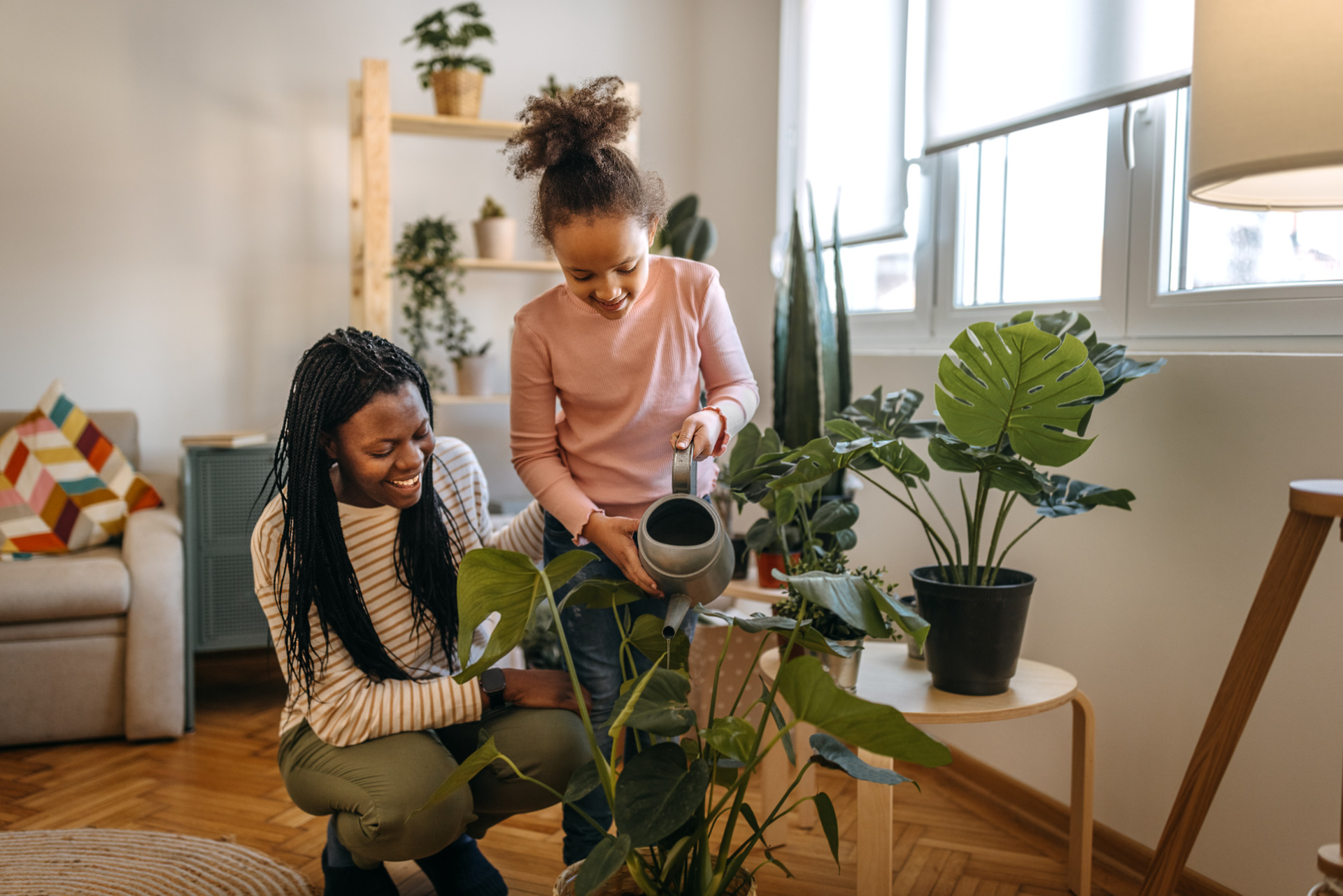 Parent et enfant prenant soin de plantes dans leur maison